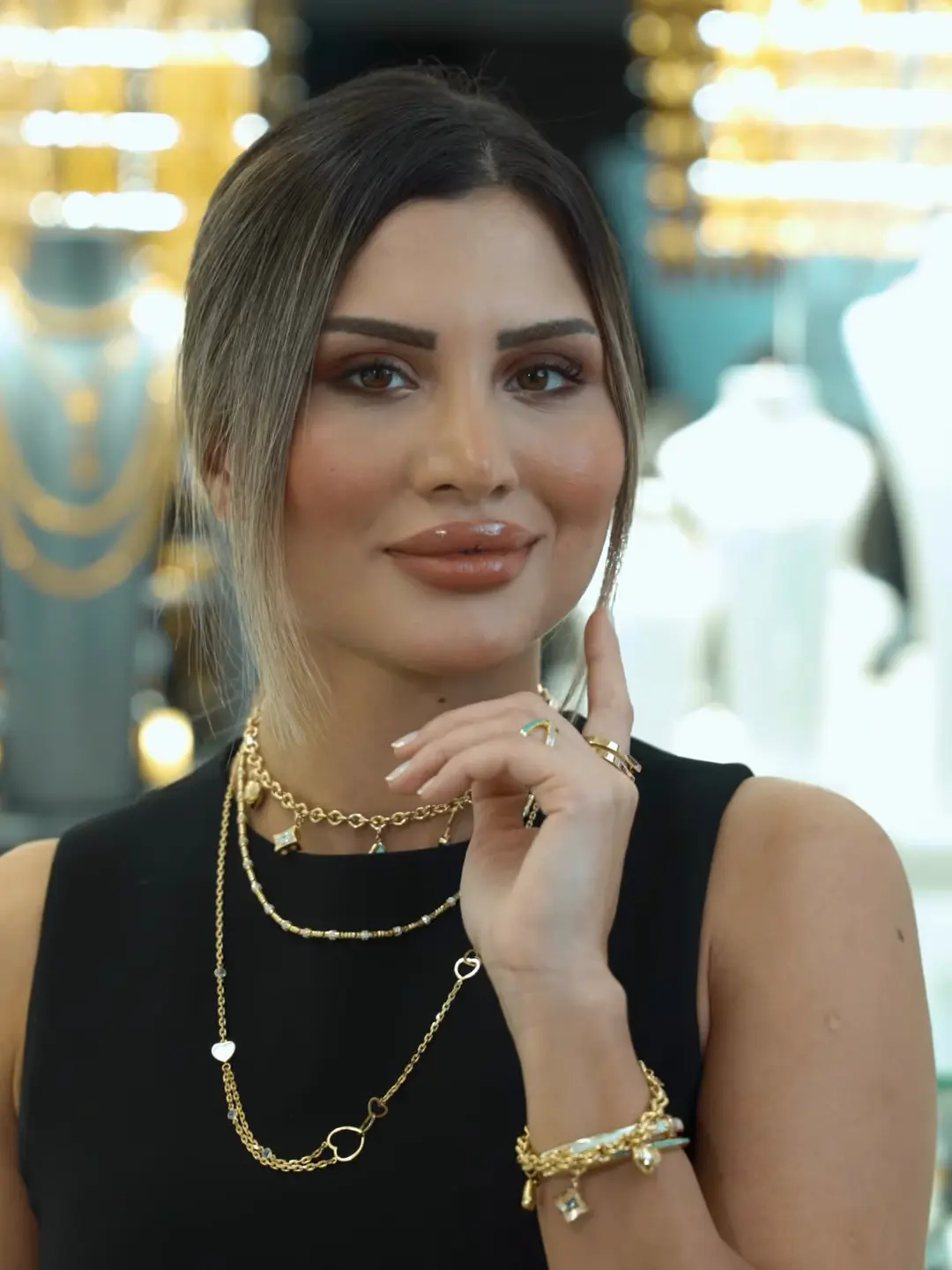 Katmanlı altın kolye ve bilekliklerle manken